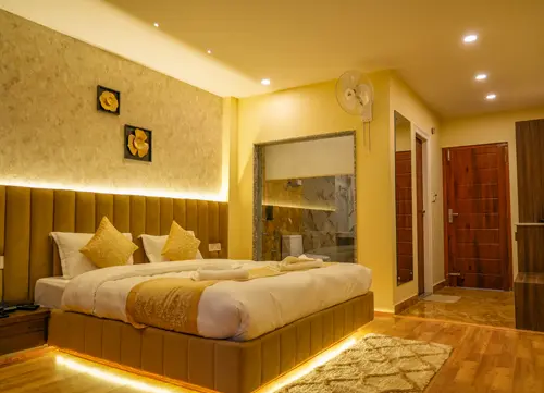 Luxury hotel room with LED-lit bed, golden cushions, and attached modern bathroom